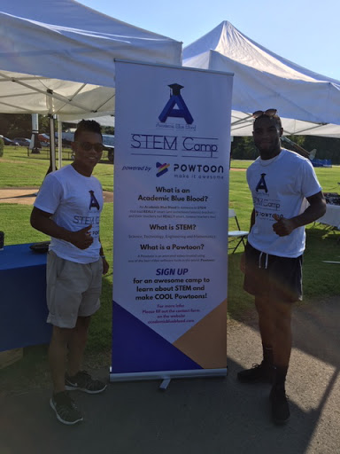 Two men standing next to a poser promoting STEM camp